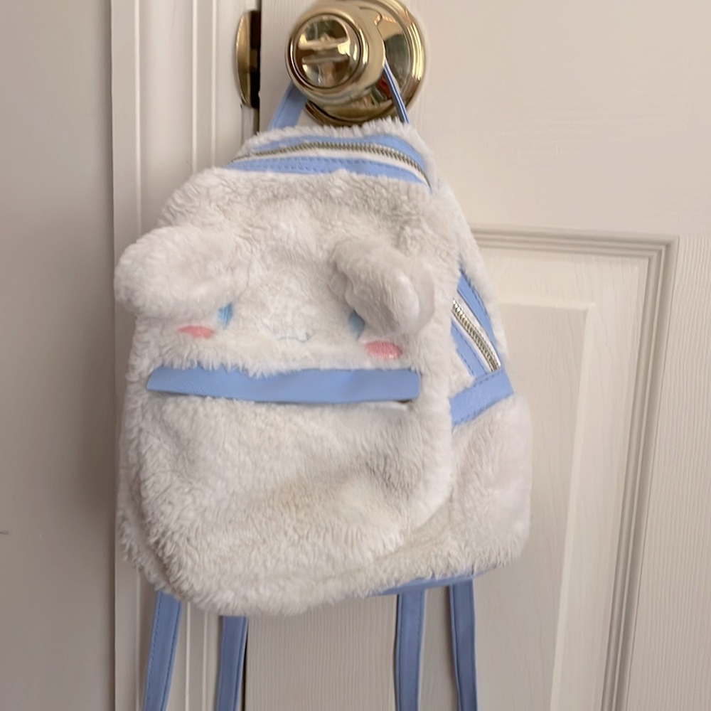 Cinnamorall bag with fluffy outside texture and blue leather textured straps.